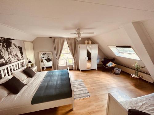 een slaapkamer met een groot bed op zolder bij Hofstede Dongen Vaart in Dongen