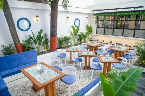a restaurant with tables and chairs and plants at The Voyage - Cafe Hostel CoWork in Pune