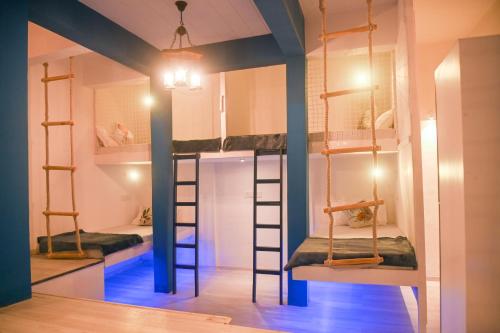 two bunk beds in a room with blue beams at The Voyage - Cafe Hostel CoWork in Pune