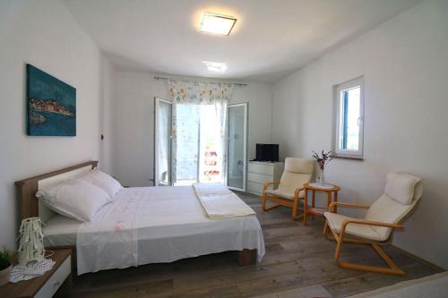 - une chambre avec un lit, deux chaises et une télévision dans l'établissement Apartment Milivoj, à Betina