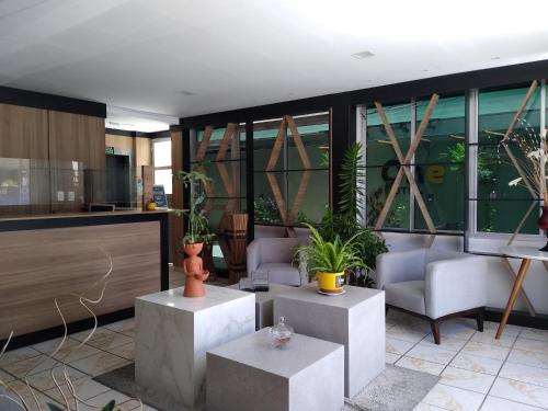 a lobby with couches and plants in a building at One Hotel in João Pessoa