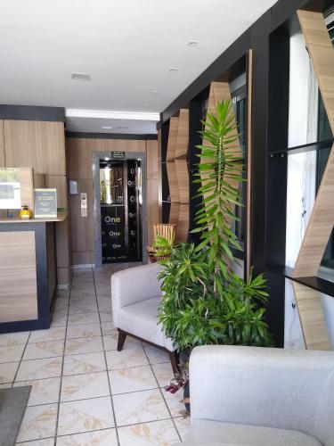 a lobby with two chairs and a palm plant in it at One Hotel in João Pessoa