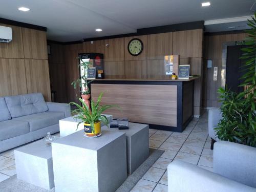 a lobby with couches and a counter with a clock at One Hotel in João Pessoa