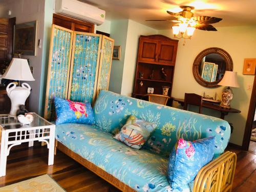 a blue couch with pillows in a living room at Coral Cove Inn in Seine Bight Village