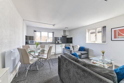 a living room with a couch and a table at Pleasure Holiday Apartments in Blackpool