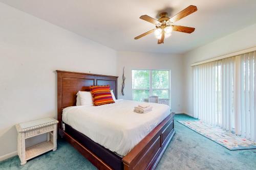 um quarto com uma cama e uma ventoinha de tecto em Seminole Wind em St. George Island