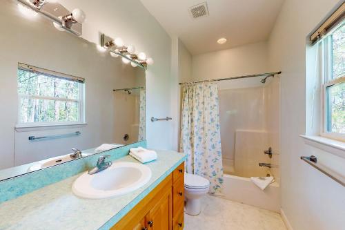 uma casa de banho com um lavatório, um WC e um chuveiro em Seminole Wind em St. George Island