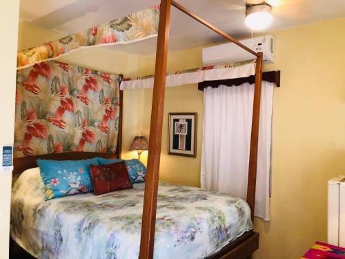 a bedroom with a canopy bed in a room at Coral Cove Inn in Maya Beach