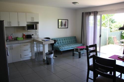 a kitchen and living room with a couch and a table at Apartamentos La Alborada Airport SJO in Alajuela City