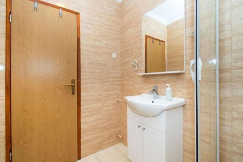 une salle de bain avec lavabo et douche dans l'établissement Apartments Igor, à Jakišnica