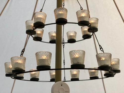 a chandelier with many glass cups on it at Home Farm Radnage Glamping Bell Tent 6, with Log Burner and Fire Pit in High Wycombe