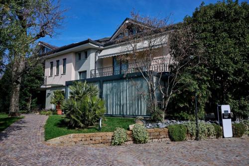 a house with a brick driveway in front of it at Like Home Boutique Hotel in Azzano San Paolo