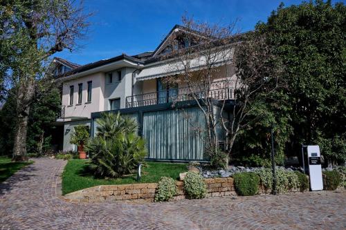 a house with a brick driveway in front of it at Like Home Boutique Hotel in Azzano San Paolo