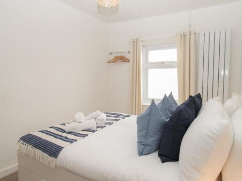a bedroom with a bed with blue and white pillows at Oystercatcher Bay in Weymouth