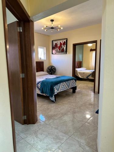 a bedroom with a bed with a blue blanket on it at Departamento en Tequila María Concepción in Tequila