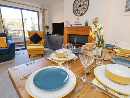 a dining room with a table with plates and wine glasses at Tennyson View in Totland