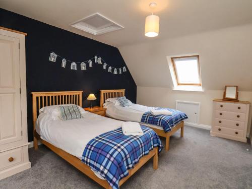 a bedroom with two beds and a black wall at Chandler's View in Whitby
