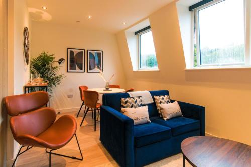 a living room with a blue couch and a table at Furness House by Pay As U Stay in Redhill