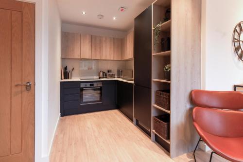 a kitchen with black cabinets and a counter top at Furness House by Pay As U Stay in Redhill