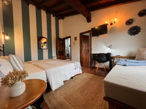 um quarto de hotel com duas camas e uma mesa em Posada La Vieja Escuela em La Revilla