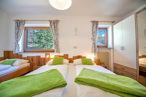 two beds in a bedroom with green towels at Bonichhof in Laion