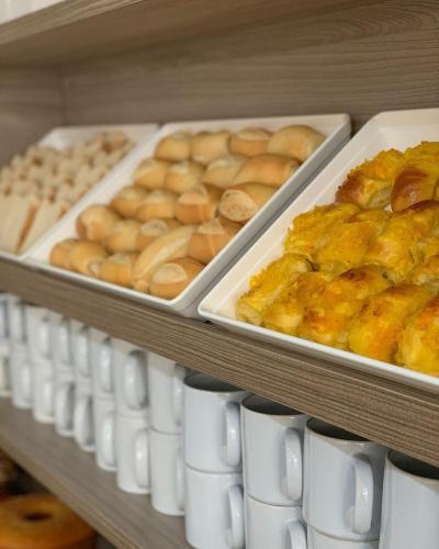 a bunch of donuts and other baked goods on shelves at One Hotel in João Pessoa