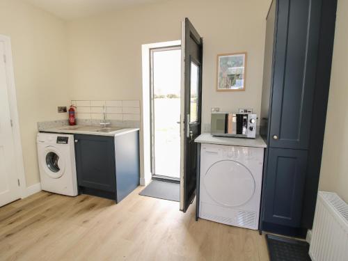 a laundry room with a washing machine and a washer at Bethania in Oswestry