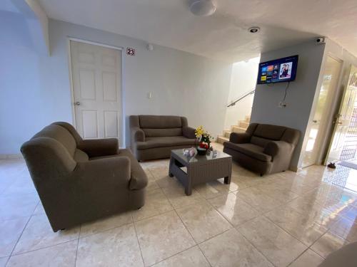 - un salon avec deux canapés et une télévision dans l'établissement Hotel Murallas Capital, à Campeche