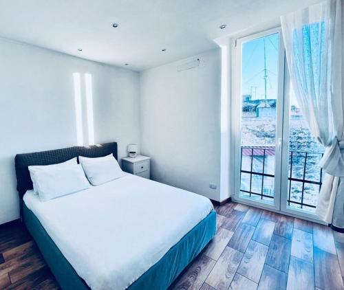 a bedroom with a bed and a large window at Macario Apartment in the Old Town in Bari
