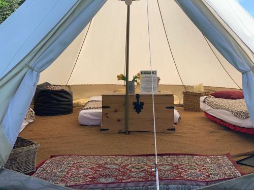 a tent with two beds and a table in it at Home Farm Radnage Glamping Bell Tent 7, with Log Burner and Fire Pit in High Wycombe