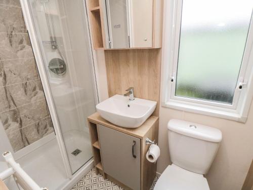 a bathroom with a toilet and a sink and a shower at 20 Wolds View in Ganton