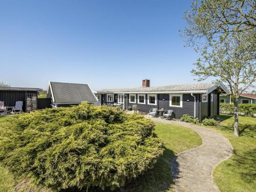 una casa con un gran arbusto delante de ella en Holiday Home Ylvie - 150m from the sea in Funen by Interhome, en Frørup