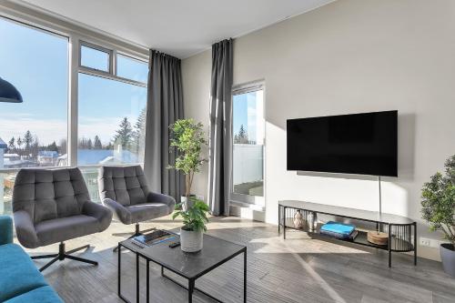 sala de estar con sofá azul y TV en Bella Apartments & Rooms, en Selfoss