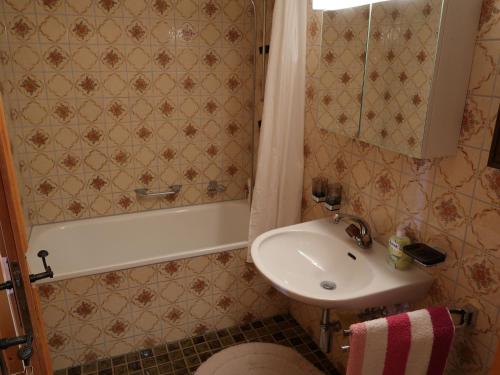 a bathroom with a sink and a bath tub and a sink at Chalet Tgaplotta by Interhome in Alvaneu