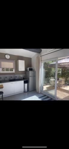 a kitchen with white cabinets and a large window at LA DOLCE VITA MAZET A GASSIN GOLFE DE SAINT TROPEZ in Gassin