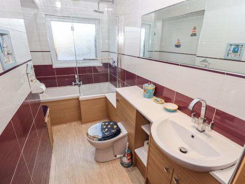 La salle de bains est pourvue d'un lavabo, de toilettes et d'une baignoire. dans l'établissement 19 Grace Crescent, à Skegness