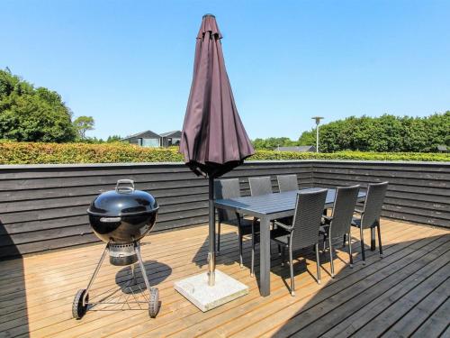 a grill and a bbq on a deck at Holiday Home Jani - 25km from the sea in Western Jutland by Interhome in Toftlund