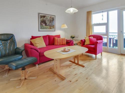 sala de estar con sofá rojo, 2 sillas y mesa en Apartment Arngerus in Western Jutland by Interhome en Højer