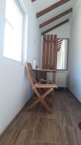 einen Holzstuhl in einem Zimmer mit Spiegel in der Unterkunft GUESTHOUSE TARA in Kolašin