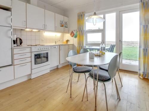 uma cozinha com uma mesa e cadeiras numa cozinha em Apartment Arngerus in Western Jutland by Interhome em Højer