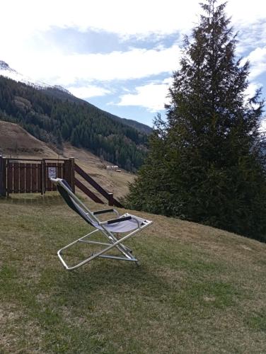 a lawn chair sitting in the grass on a hill at THE LITTLE NEST in Valdisotto