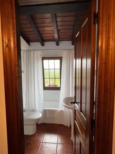 uma casa de banho com um WC, um lavatório e uma janela em Posada La Vieja Escuela em La Revilla