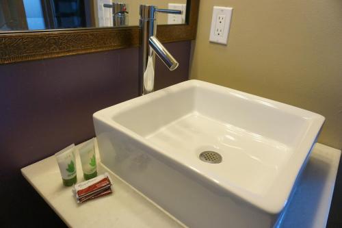lavabo blanco en el baño con espejo en LiA Hotel, en San Carlos