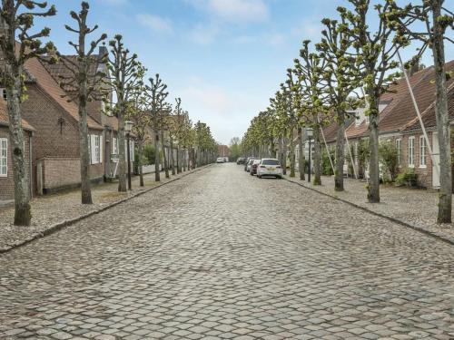 a cobblestone street with houses and trees on both sides at Holiday Home Ajna - 9-8km from the sea in Western Jutland by Interhome in Tønder