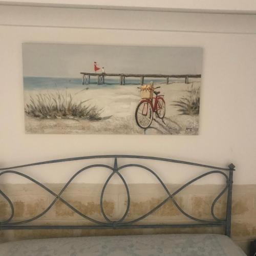 uma pintura de uma bicicleta ao lado de uma pintura de um cais em Casa Pina em Rutigliano