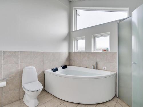 baño con bañera, aseo y ventana en Holiday Home Heide - 750m to the inlet in Western Jutland by Interhome, en Tarm