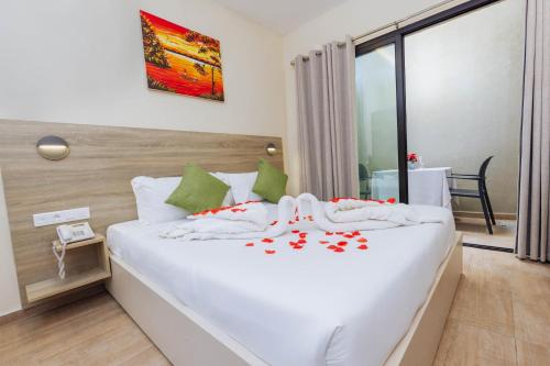 a bedroom with a white bed with red flowers on it at Silver Moon Hotel in Abidjan