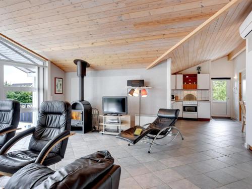 uma sala de estar com cadeiras de couro e uma televisão em Holiday Home Ingbritt - 700m to the inlet in Western Jutland by Interhome em Tarm