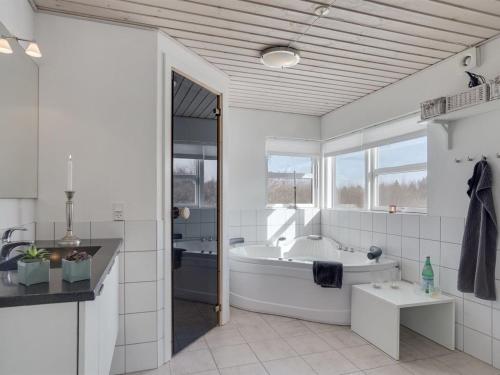 a white bathroom with a tub and a sink at Holiday Home Asel - 4km from the sea in NW Jutland by Interhome in Brovst