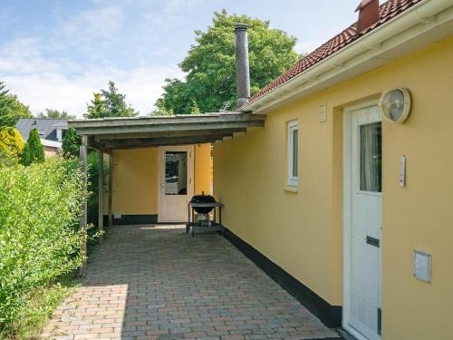 a yellow house with a brick walkway leading to a door at Holiday Home Øthi in Western Jutland by Interhome in Ribe